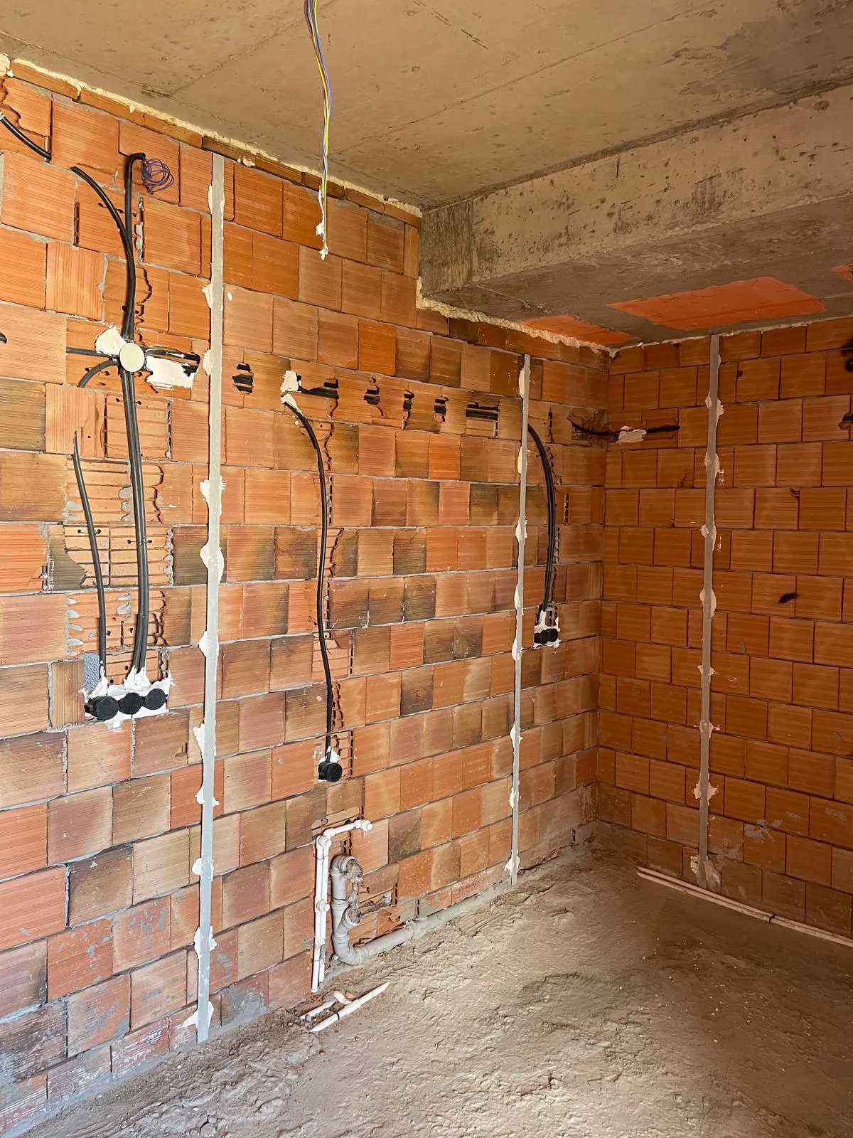 Tuğla duvarda elektrik tesisatı borularının yerleştirildiği uygulama aşaması